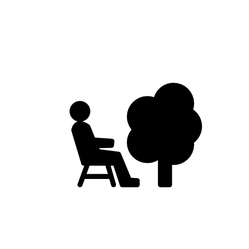Person sitting on a chair beside a tree