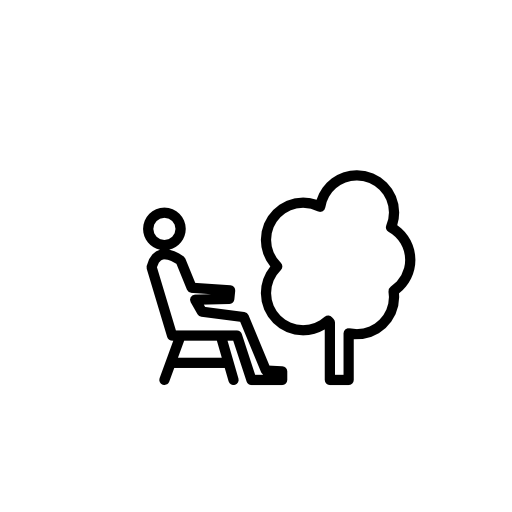 Person sitting on a chair beside a tree