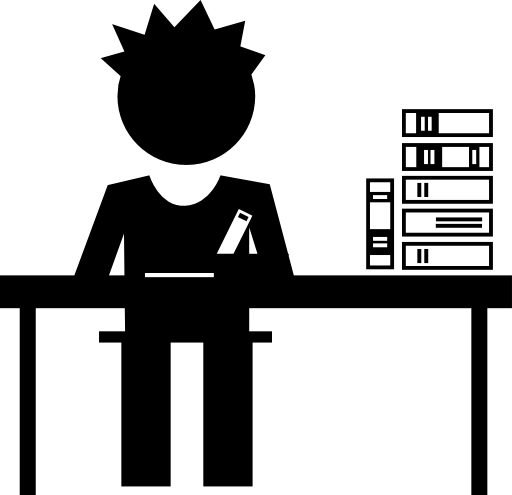 Student boy sitting behind a table with books stack at his side