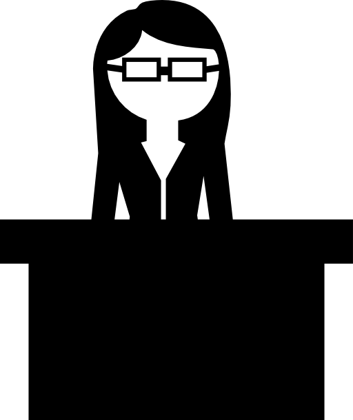Teacher with eyeglasses behind her desk